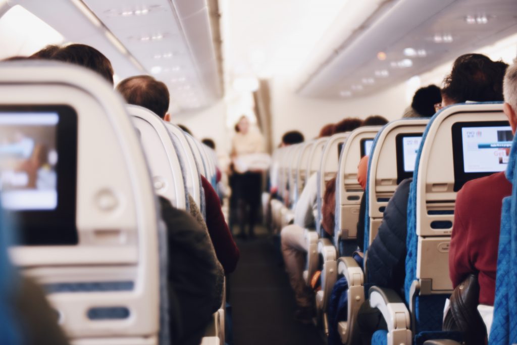 Pessoas sentadas nas poltronas do avião durante voo