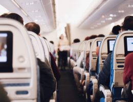 Pessoas sentadas nas poltronas do avião durante voo